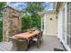 Outdoor dining area on a deck with a stone fireplace and views of the surrounding trees at 6873 Pine Moss Ln, Clover, SC 29710