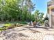 Spacious backyard featuring a stone patio, dining set, lush lawn, a water fountain, and mature trees at 705 Vintage Creek Dr, Matthews, NC 28104
