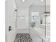 White shower with pebble floor and bench adjacent to a soaking tub with white cabinets at 705 Vintage Creek Dr, Matthews, NC 28104