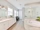 Bright bathroom with a soaking tub, glass shower, and dual sink vanity at 705 Vintage Creek Dr, Matthews, NC 28104
