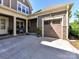 Home exterior featuring a two-car garage, stone accents, well-maintained landscaping and covered entryway at 705 Vintage Creek Dr, Matthews, NC 28104