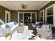 Cozy covered patio with comfortable seating and sliding glass doors leading to a well-lit interior space at 705 Vintage Creek Dr, Matthews, NC 28104