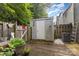 Backyard with a wooden deck, storage shed, air conditioning, and greenery at 7304 Pebblestone Dr, Charlotte, NC 28212