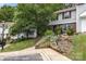 Exterior view of home featuring mature landscaping, a quaint garden, and lovely curb appeal at 7304 Pebblestone Dr, Charlotte, NC 28212