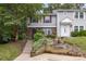 Close view of the exterior showing meticulous landscaping featuring mature trees, various flowers, and green bushes at 7304 Pebblestone Dr, Charlotte, NC 28212