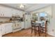 Eat-in kitchen features white cabinets and a large window with a view at 7304 Pebblestone Dr, Charlotte, NC 28212