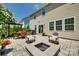 Backyard patio features an outdoor dining set, a fire pit, and a pergola, surrounded by lush green landscaping at 7930 Kelburn Ln, Charlotte, NC 28273