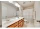 Bright bathroom featuring a double vanity with wood cabinets, framed mirror, shower with curtain, and modern fixtures at 7930 Kelburn Ln, Charlotte, NC 28273