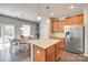 A kitchen with wood cabinets, stainless appliances, and granite countertops, next to a dining area at 7930 Kelburn Ln, Charlotte, NC 28273