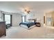 Spacious main bedroom features carpet flooring, ceiling fan, sitting area, and ensuite bathroom entrance at 7930 Kelburn Ln, Charlotte, NC 28273