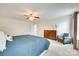 Bright main bedroom features a ceiling fan, carpet flooring, and a sitting area with a gray chair at 7930 Kelburn Ln, Charlotte, NC 28273
