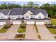 Aerial view of modern townhomes featuring manicured lawns, driveways, and lush landscaping at 9009 Odell Corners Nw Blvd, Concord, NC 28027