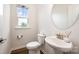 Bright half bathroom featuring a white pedestal sink, round mirror, and window at 9009 Odell Corners Nw Blvd, Concord, NC 28027