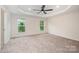 Spacious bedroom featuring plush carpeting, a ceiling fan, and two bright windows at 9009 Odell Corners Nw Blvd, Concord, NC 28027