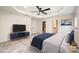 Spacious bedroom with a tray ceiling, ceiling fan, television, and an ensuite bathroom at 9009 Odell Corners Nw Blvd, Concord, NC 28027