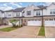 Attractive townhome showcasing brick details, a single-car garage, and lush green lawn at 9009 Odell Corners Nw Blvd, Concord, NC 28027