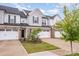 Attractive townhome showcasing brick details, a single-car garage, and lush green lawn at 9009 Odell Corners Nw Blvd, Concord, NC 28027