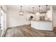 Open-concept living space with hardwood floors, contemporary lighting, and kitchen view at 9009 Odell Corners Nw Blvd, Concord, NC 28027