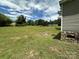 Lush backyard with well-maintained lawn, landscaping, and wooded border at 9044 Forington Ln, Gastonia, NC 28056
