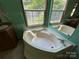 Relaxing bathroom featuring a corner soaking tub and abundant natural light at 9044 Forington Ln, Gastonia, NC 28056