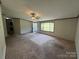 Bright living room featuring a large window and cozy carpet, ready for personal touches at 9044 Forington Ln, Gastonia, NC 28056