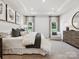 Spacious main bedroom featuring tray ceiling, neutral decor and accent chair sitting area at 1029 Mapletree Ln, Indian Trail, NC 28079