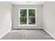 A bright bedroom featuring neutral walls, plush carpet, and natural light streaming through double windows at 105 Spring Garden Dr, Gastonia, NC 28052