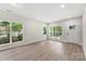 Bright living room featuring wood floors, large windows and a white door to exterior at 105 Spring Garden Dr, Gastonia, NC 28052