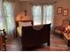 Bedroom with wood floors, a bed, side table, rocking chair, and sheer curtains at 1115 John Short Rd, Indian Land, SC 29707
