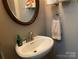 Cozy powder room featuring a round mirror, sleek sink, and stylish fixtures at 1115 John Short Rd, Indian Land, SC 29707