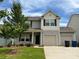 Charming two-story home with a two-car garage, manicured lawn, and a beautiful sky overhead at 124 Canada Dr # 45, Statesville, NC 28166