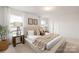 A bright main bedroom with neutral tones, carpeted floors, large windows, and a plush bed with decorative pillows at 124 Canada Dr # 45, Statesville, NC 28166