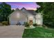 Inviting exterior with a two-car garage and a well-manicured lawn and attractive architectural elements at dusk at 133 37Th Avenue Nw Pl, Hickory, NC 28601