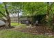 Backyard with mature tree, wood fence, and comfortable seating around a fire pit at 1729 Kensington Dr, Charlotte, NC 28205