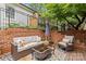 Cozy backyard deck area with outdoor seating, a coffee table, and brick accents at 1729 Kensington Dr, Charlotte, NC 28205