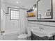 Bright bathroom featuring black and white tile, glass block window, and black fixtures at 1729 Kensington Dr, Charlotte, NC 28205