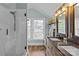 Bright bathroom featuring a double vanity, tile shower with glass door, and modern fixtures at 1729 Kensington Dr, Charlotte, NC 28205