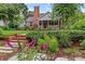 Charming brick home featuring a cozy front porch, lush landscaping, and a brick chimney at 1729 Kensington Dr, Charlotte, NC 28205