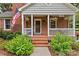 Inviting brick porch with American flag, hanging flower baskets, and seating at 1729 Kensington Dr, Charlotte, NC 28205