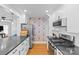 Bright kitchen features modern stainless steel appliances, black counters, and unique colorful wallpaper at 1729 Kensington Dr, Charlotte, NC 28205