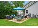 Back patio featuring cushioned wicker furniture, grill, and a bright blue umbrella by the house at 204 Craig St, Mount Holly, NC 28120