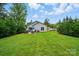Expansive backyard featuring a patio with seating, lush lawn, trees, and the home's exterior at 204 Craig St, Mount Holly, NC 28120