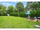 Large backyard featuring a patio, lush lawn, mature trees and landscaping and a storage shed at 204 Craig St, Mount Holly, NC 28120
