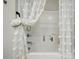 Cozy bathtub and shower with tiled walls and a decorative white curtain at 204 Craig St, Mount Holly, NC 28120