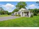 Charming single-story home with covered porch and cozy seating, complemented by a well-maintained front yard at 204 Craig St, Mount Holly, NC 28120