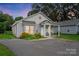 Charming single-story home with covered porch, cozy seating, neat landscaping, and a freshly paved driveway at 204 Craig St, Mount Holly, NC 28120