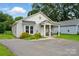Charming single-story home with covered porch, cozy seating, neat landscaping, and a freshly paved driveway at 204 Craig St, Mount Holly, NC 28120