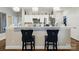 Kitchen area featuring white cabinets, stainless steel appliances, and bar seating with stylish black chairs at 204 Craig St, Mount Holly, NC 28120