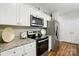 Well-equipped kitchen showcasing white cabinets, stainless steel appliances, and granite countertops at 204 Craig St, Mount Holly, NC 28120