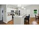 Open kitchen with white cabinets, stainless steel appliances, bar seating and decorative lighting at 204 Craig St, Mount Holly, NC 28120